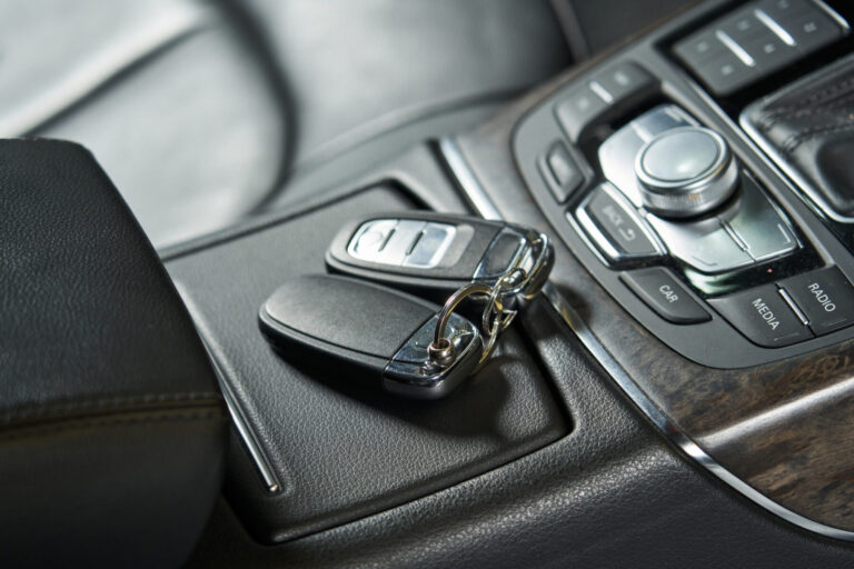 Car keys lie on a closed glove box and an audio control unit